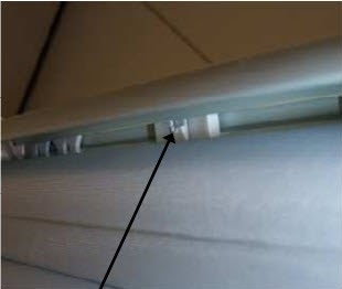 Looking up toward the front of the rail, in between the fabric roll, locate the release tab..jpg